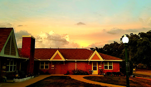 A charming house framed by a beautiful sunset sky.
