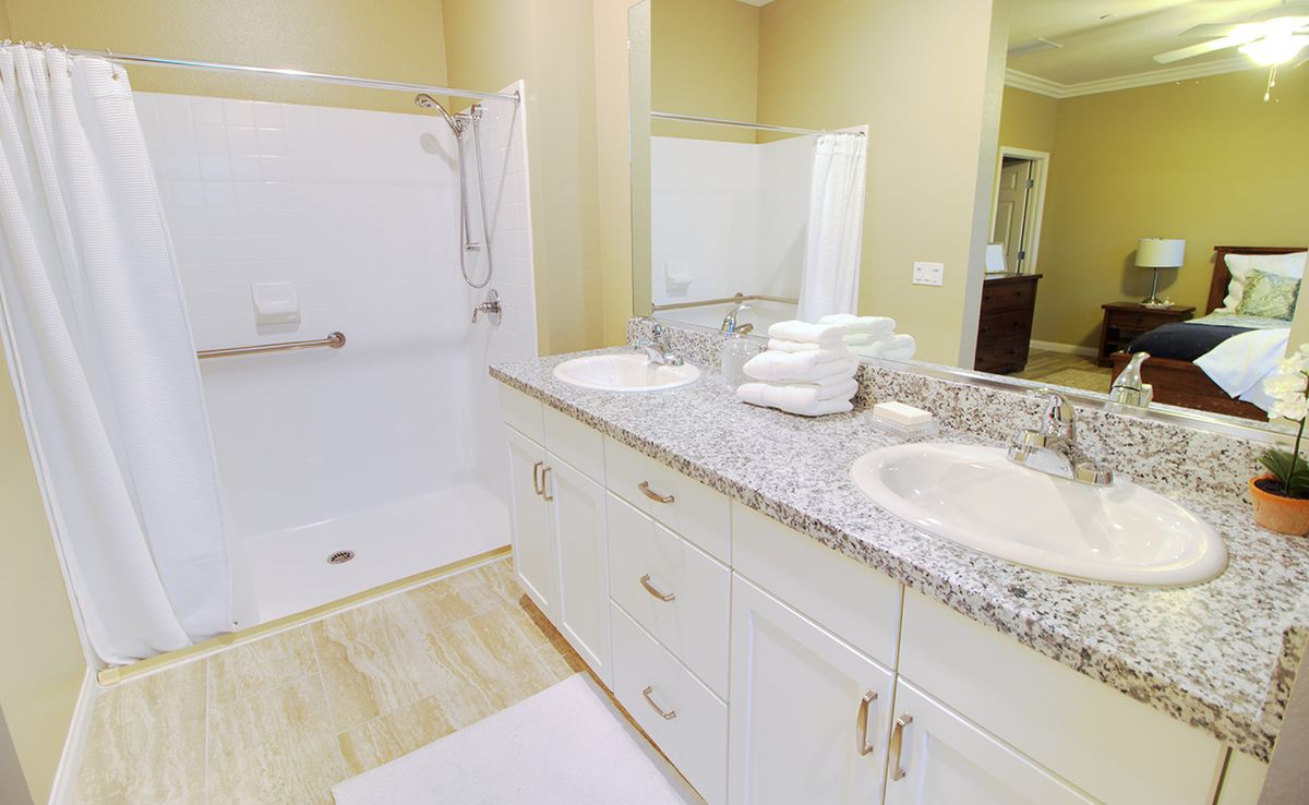 A modern bathroom with a spacious double sink vanity and walk-in shower.
