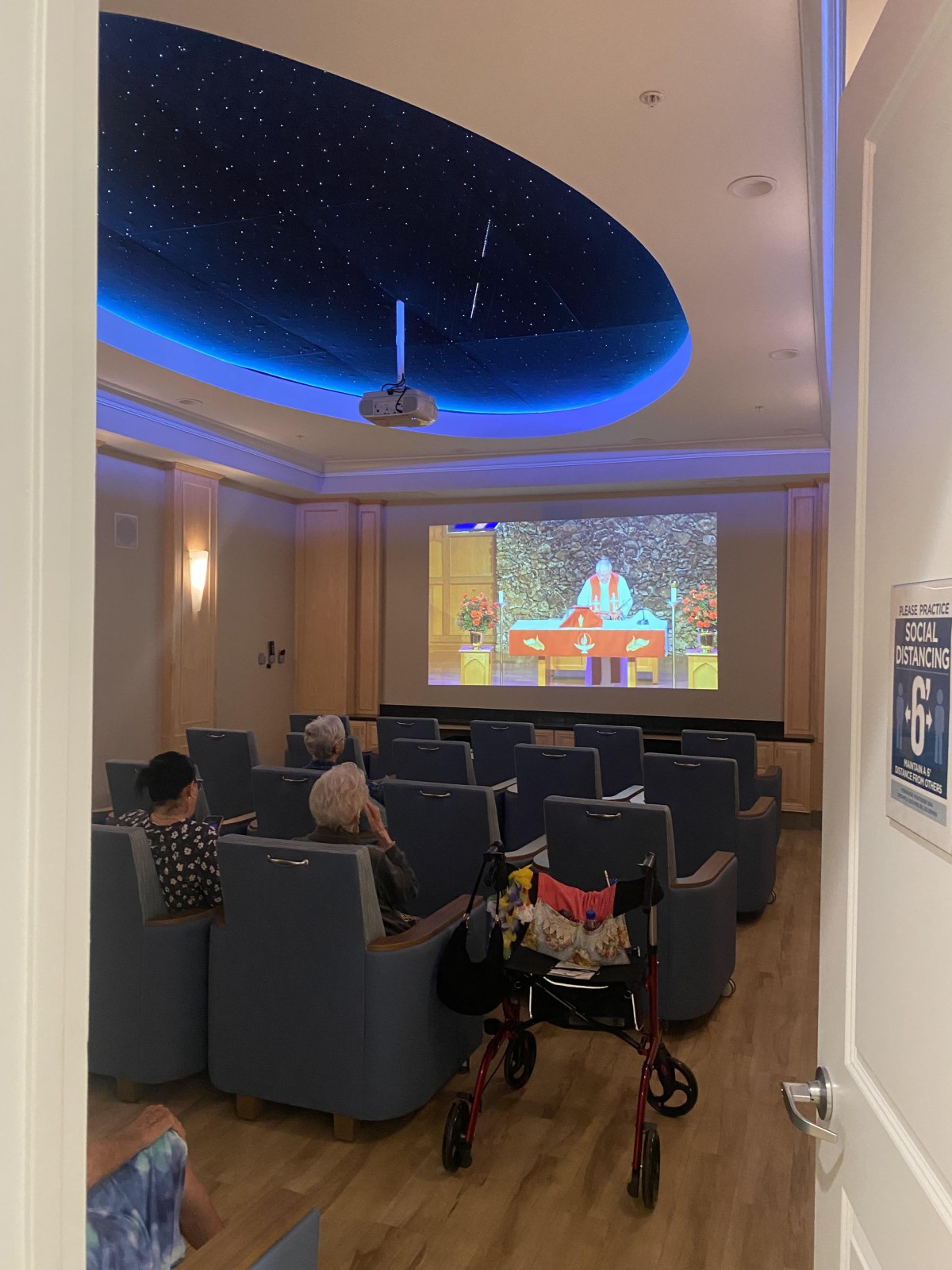 A small group of people watching a movie in a cozy indoor theater setting.