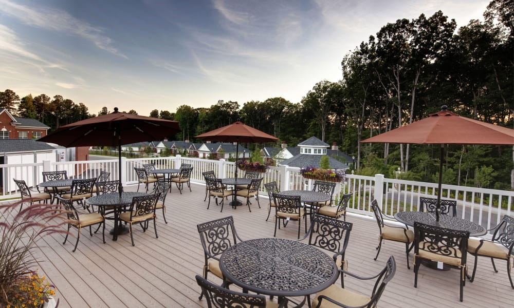 An inviting outdoor patio with tables and chairs overlooking a scenic lake.