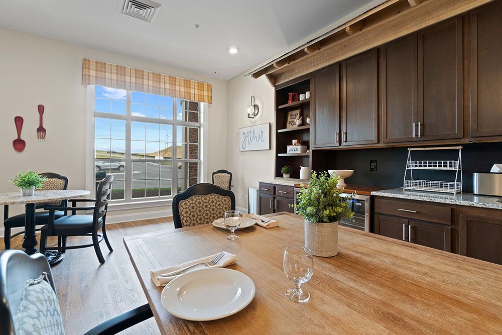 A cozy kitchen and dining area with wooden cabinetry and a sunlit table setting.