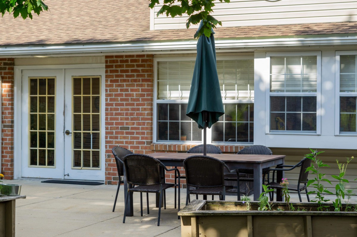 A patio with outdoor furniture set against a brick wall.