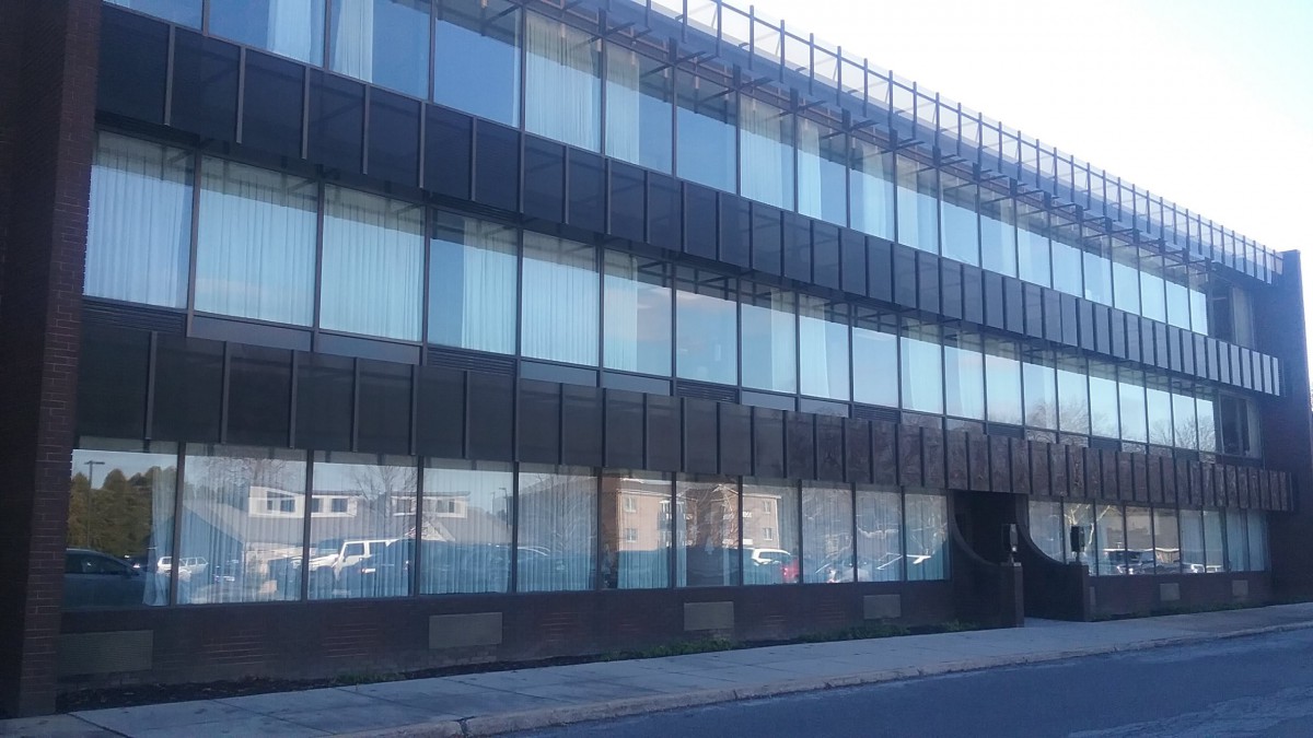 A modern office building with a glass facade in an urban setting.