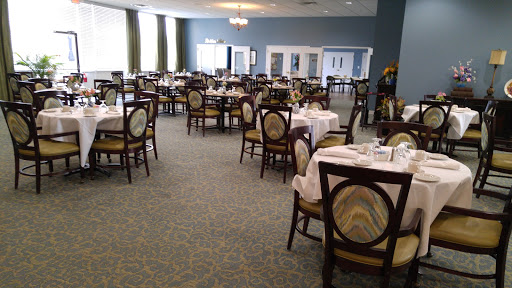 A spacious dining area set for guests, featuring neatly arranged tables and chairs.