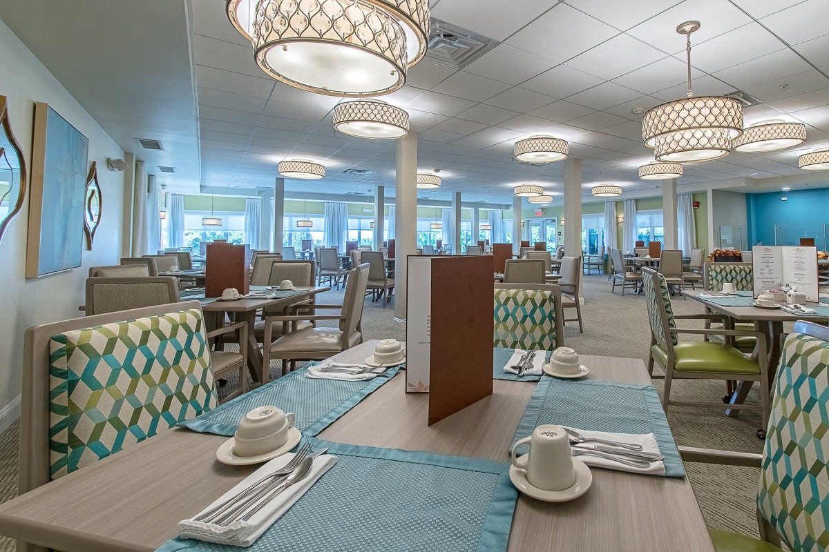 An elegant restaurant dining area with neatly arranged tables and stylish chandeliers.