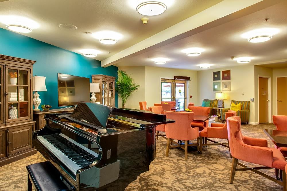 A modern lounge with a grand piano and comfortable seating arrangement.