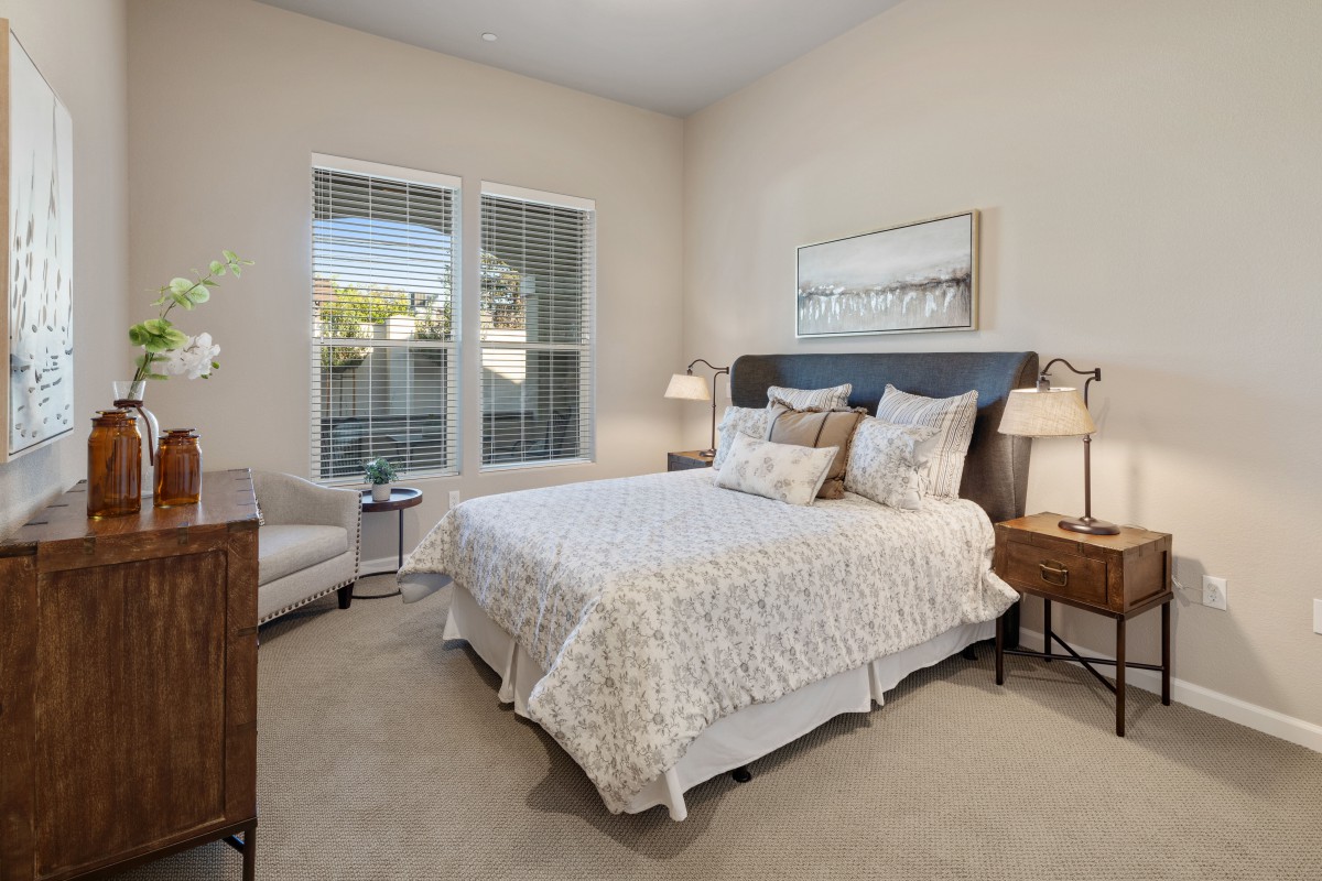 A cozy bedroom with a neatly made bed and stylish interior decor.