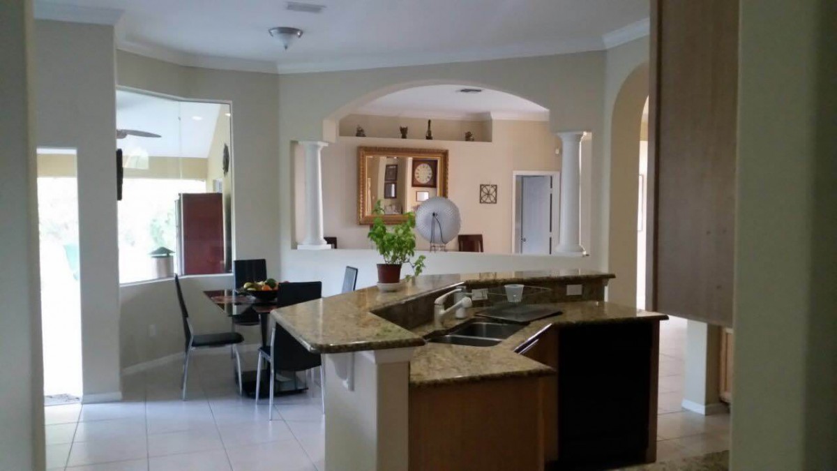 A modern kitchen with an island countertop and adjoining dining area.