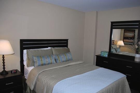 A cozy bedroom with a neatly made bed and matching furniture.