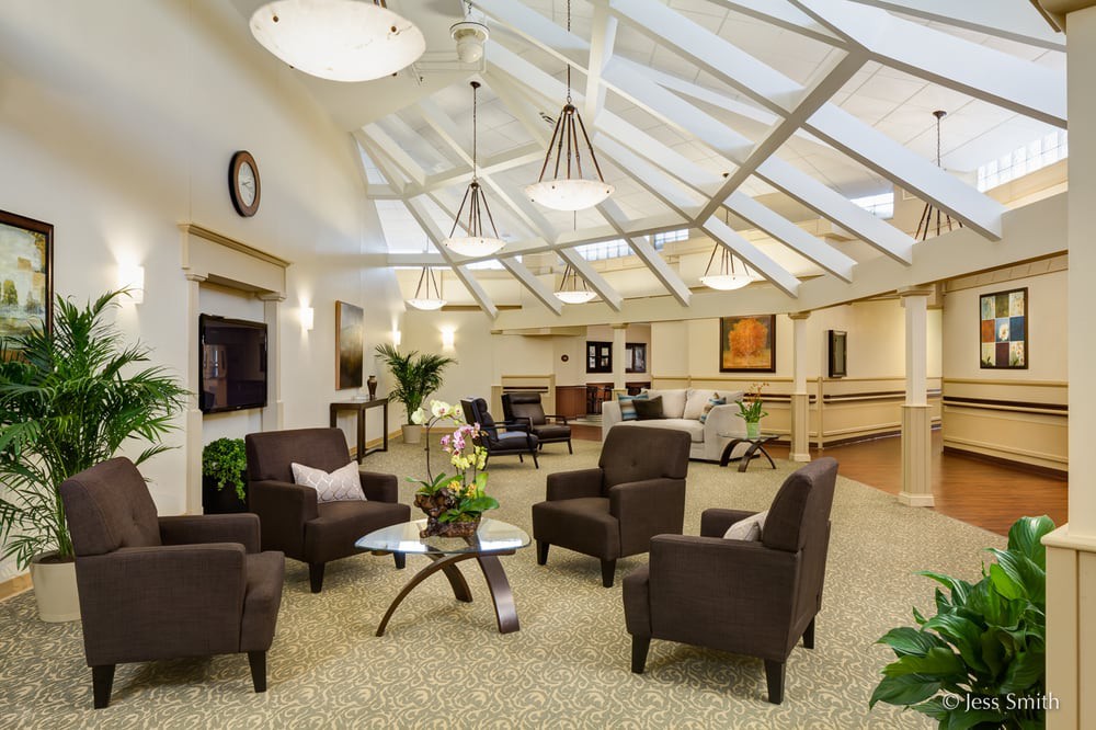A modern lounge area with comfortable seating and ample natural light from skylights.