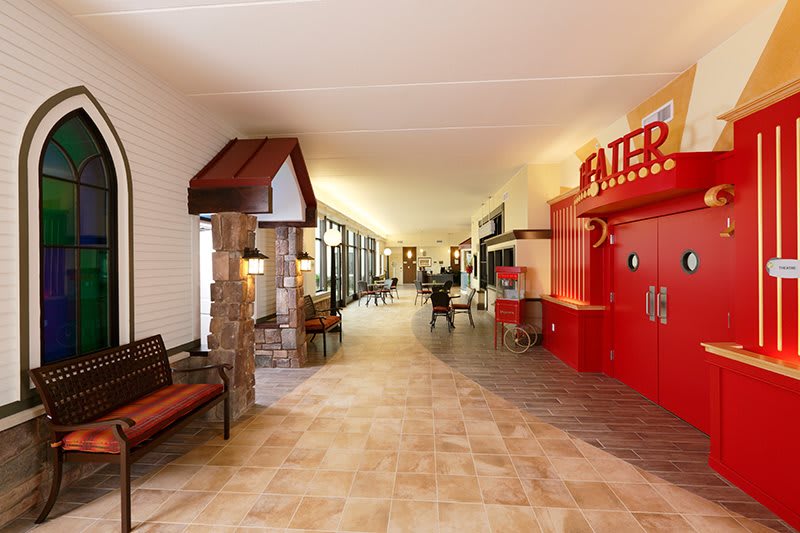 A spacious hallway with seating areas and a theater entrance.