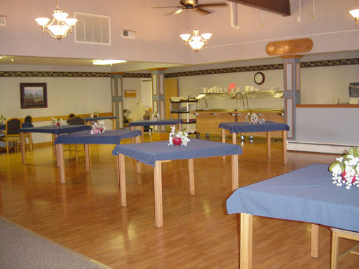 A spacious dining area featuring tables with blue cloths, ready for customers.