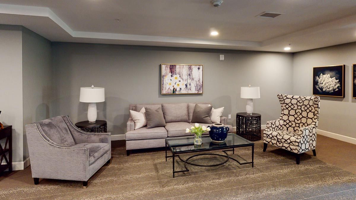 A modern living room with a comfortable sofa, glass coffee table, and stylish lamps.