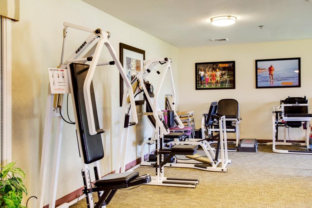 A small gym with various exercise machines and equipment.