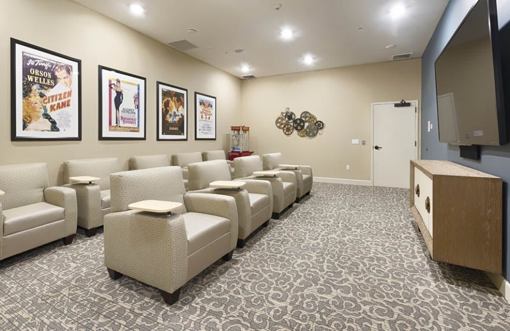 A cozy lounge area with comfortable chairs, decorative posters on the wall, and patterned carpeting.