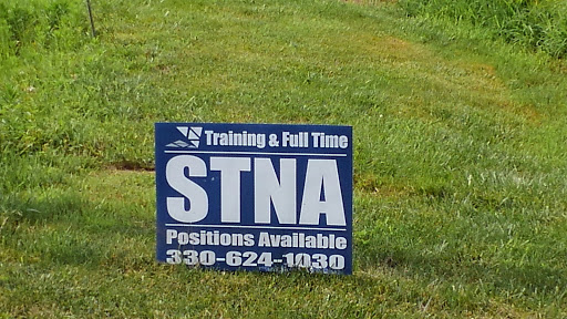 A sign advertising available STNA positions with training and full-time opportunities.