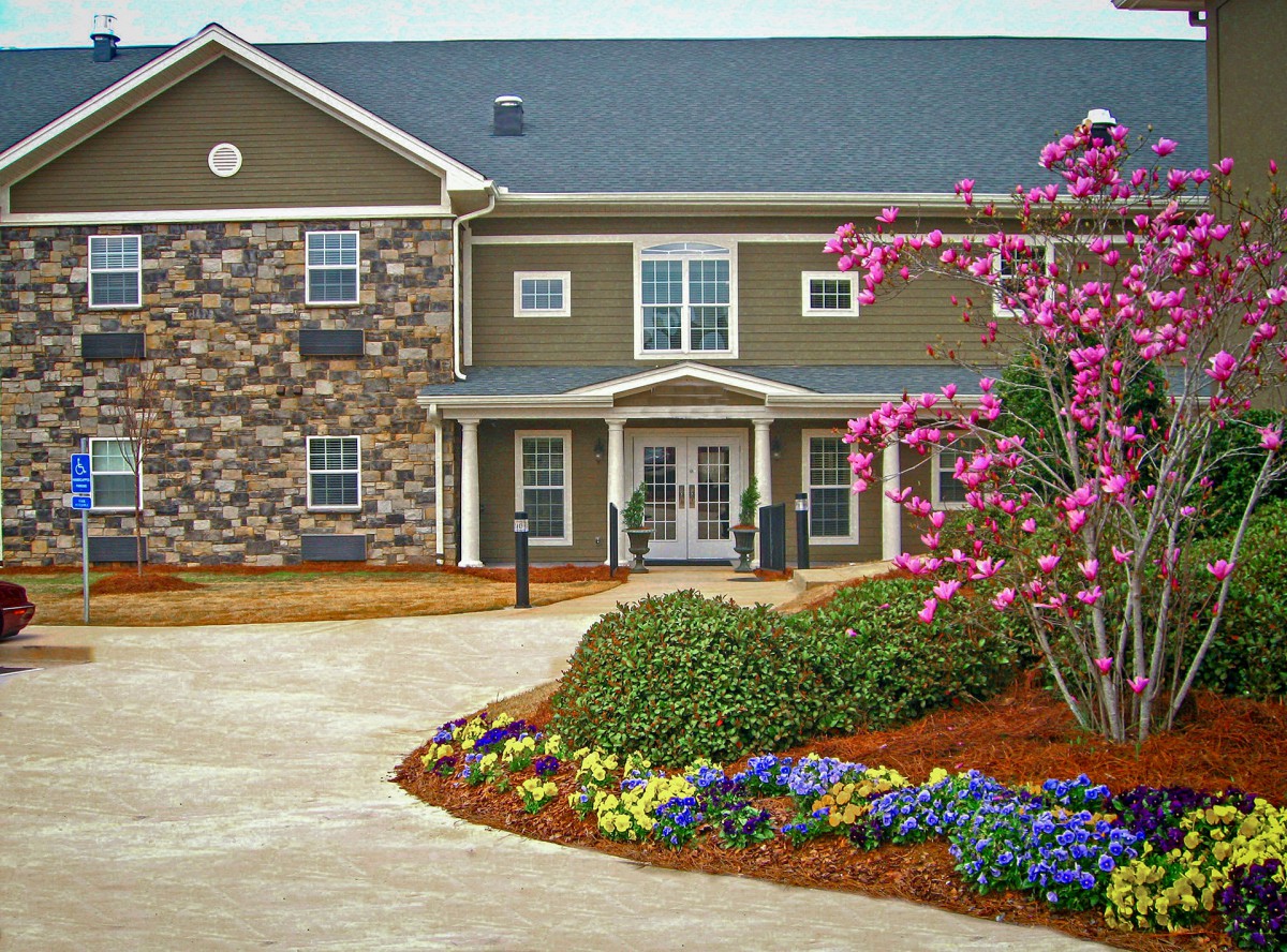 A beautifully landscaped residential building with colorful flowers.