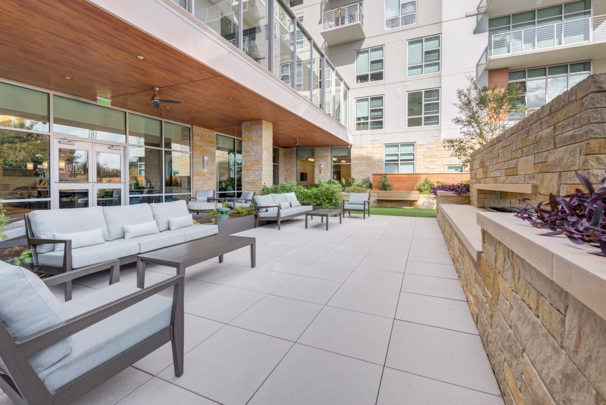 A modern outdoor patio area with comfortable seating in an apartment complex.