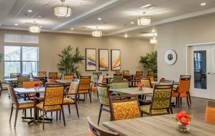 A spacious dining room with colorful chairs and modern decor.