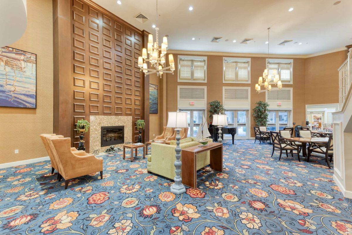 Elegant lobby with chandeliers, a fireplace, and colorful decor.