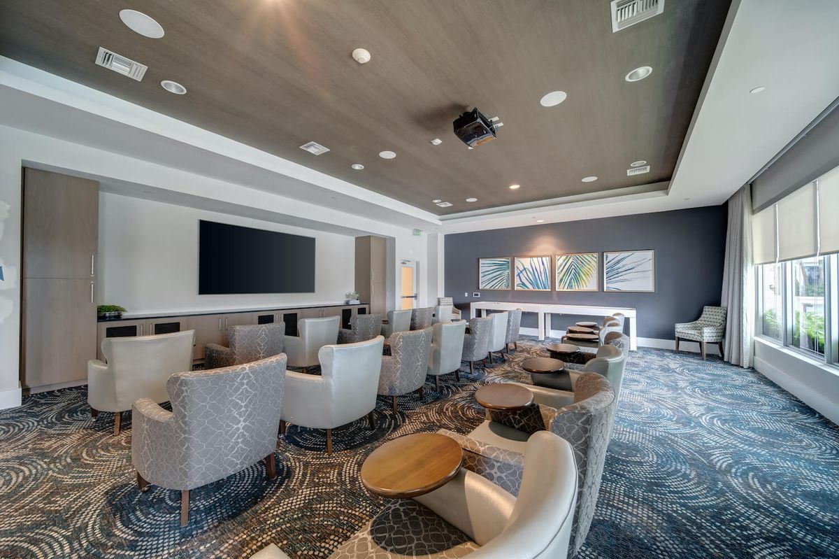 A modern conference room with comfortable seating and a large screen.