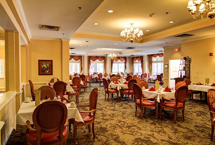 An elegant restaurant dining area with neatly arranged tables and classic chandeliers.