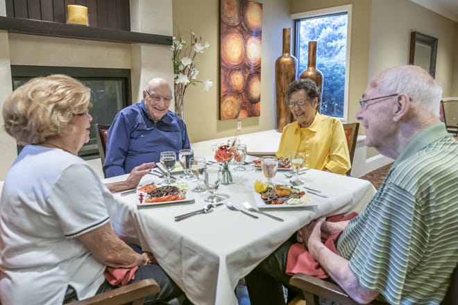 A group of seniors enjoying a meal together at a dining table.