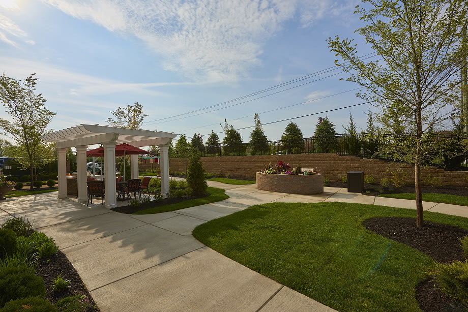 A beautifully landscaped backyard featuring a pergola and outdoor seating area.