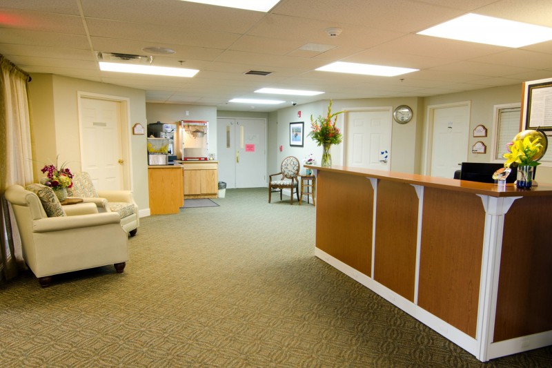 A cozy waiting room with a reception desk and seating area.