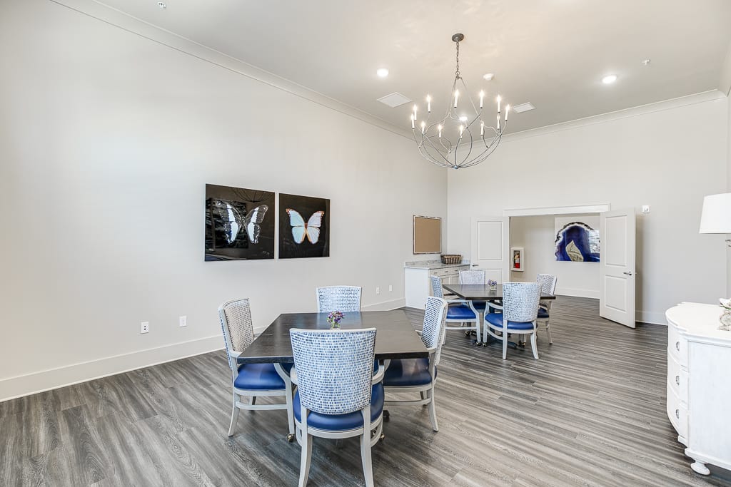 A modern dining area with elegant lighting and butterfly artwork on the walls.