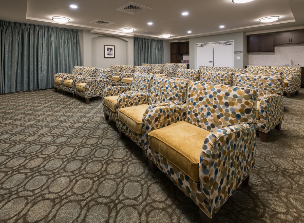 A modern conference room with patterned seating and a carpeted floor.