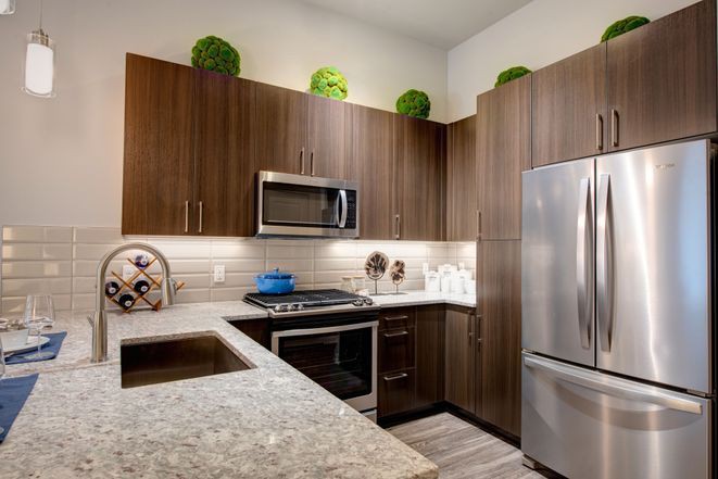 A modern kitchen featuring wood cabinets and stainless steel appliances.