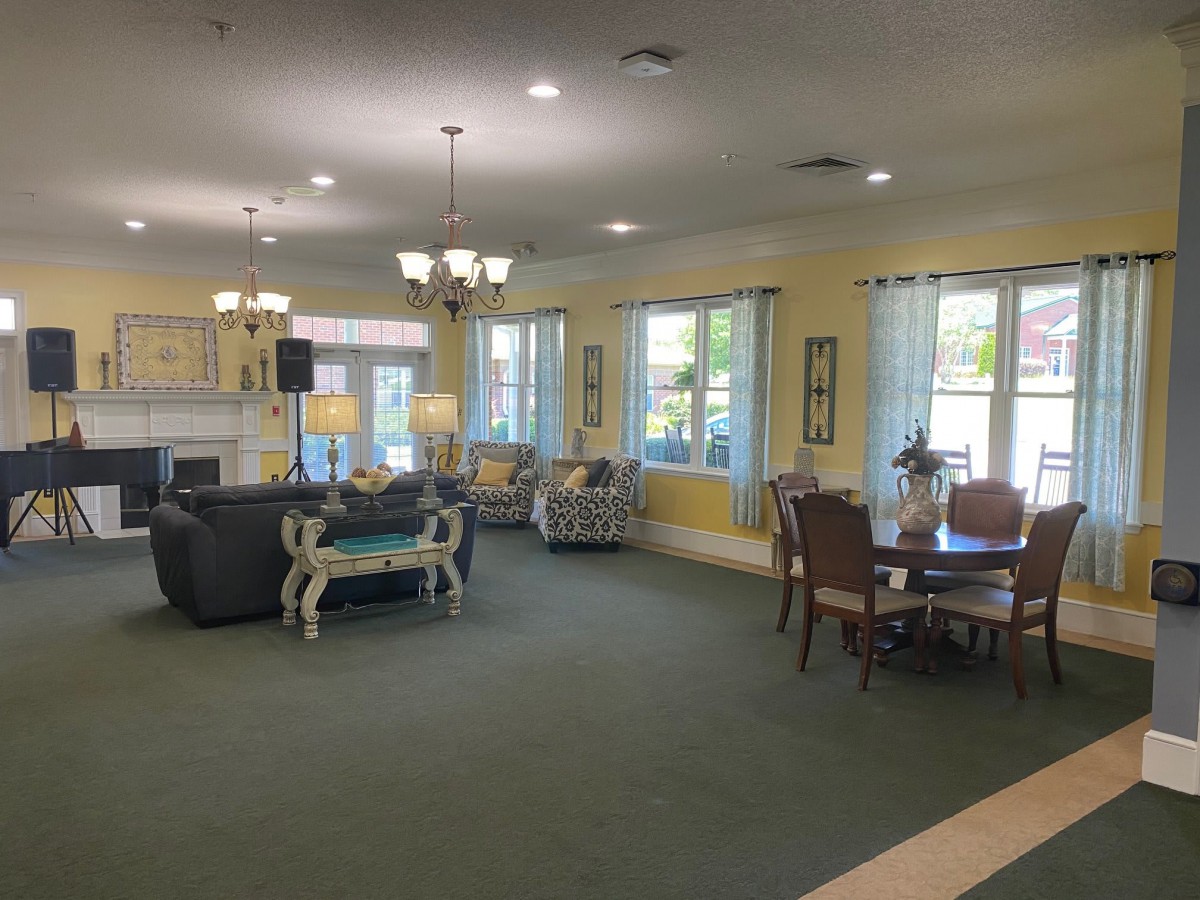 A spacious living room with sofas, tables, and large windows providing ample natural light.