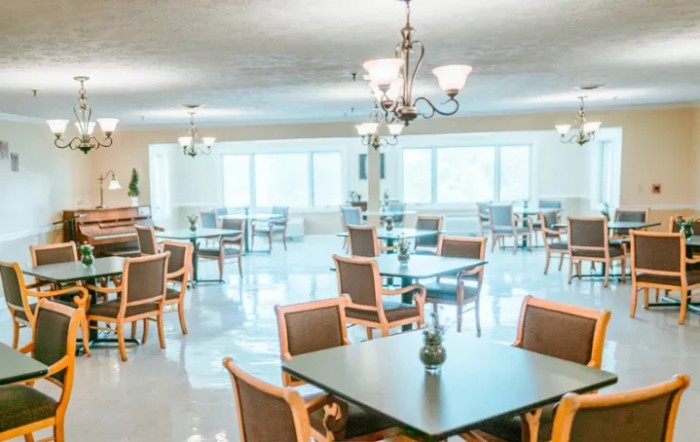A bright and spacious dining room with tables and chairs arranged neatly under elegant lighting.