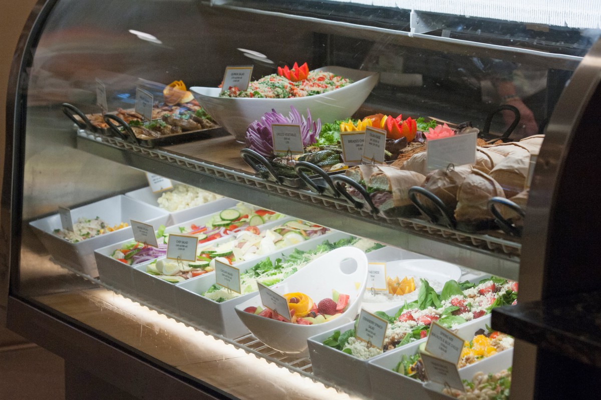 A deli counter showcasing a variety of sandwiches and salads with fresh ingredients.