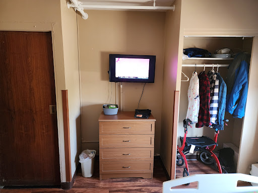 A compact room featuring a dresser, television, and closet.