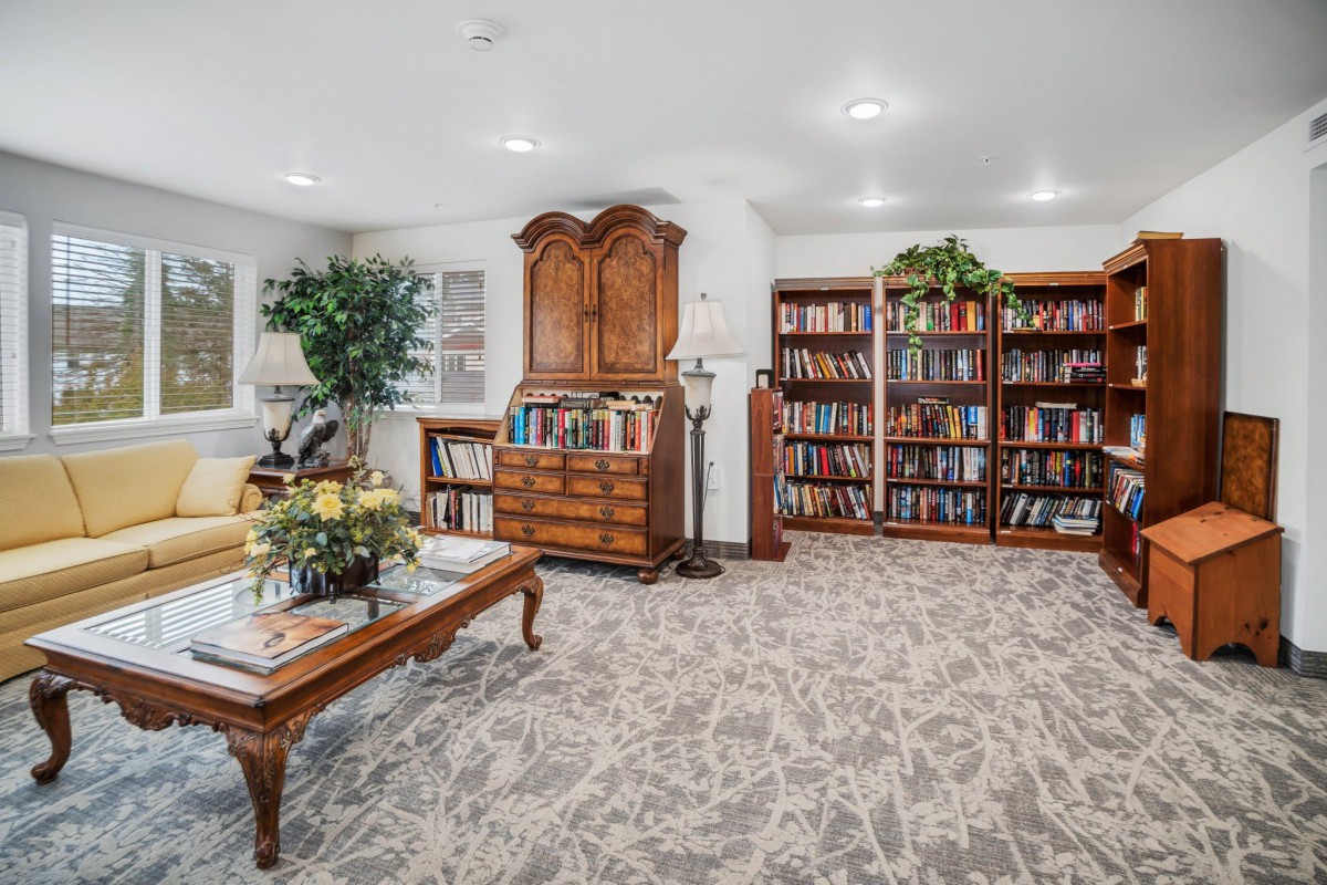 A cozy library room with bookshelves and elegant furniture, perfect for reading.