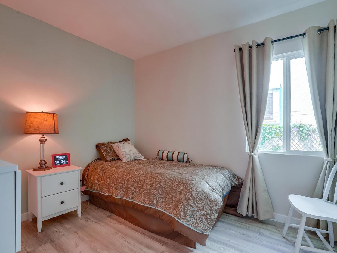 A cozy bedroom with a single bed and warm lighting.