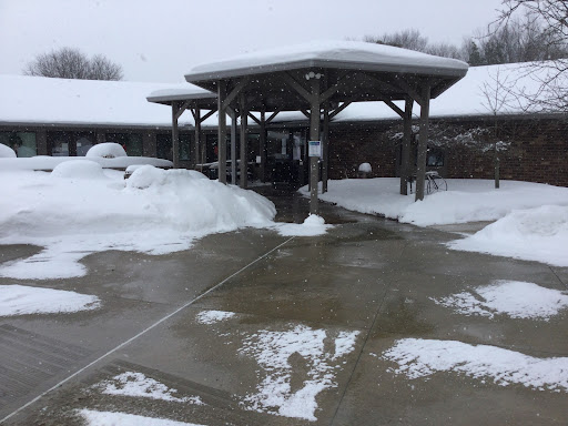 A snowy scene showcasing a building entrance covered in snow with a slushy pathway.