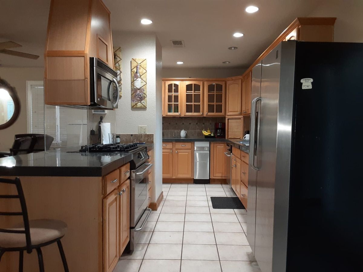 A modern kitchen with wooden cabinets and stainless steel appliances.