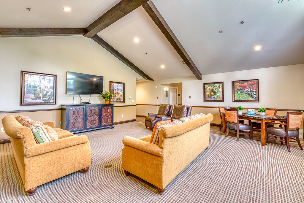 Spacious living room with comfortable seating, a television, and decorative artwork.