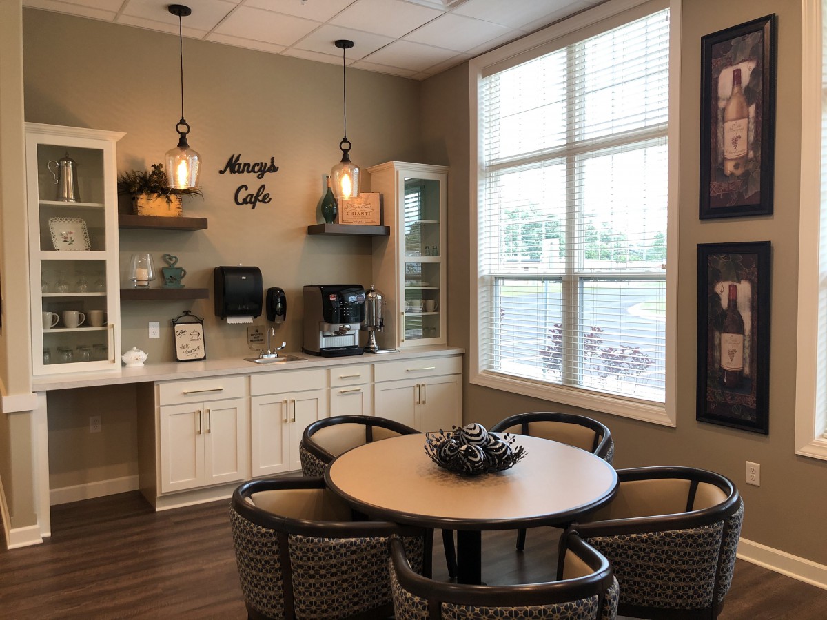 A cozy cafe interior with a seating area and coffee station.