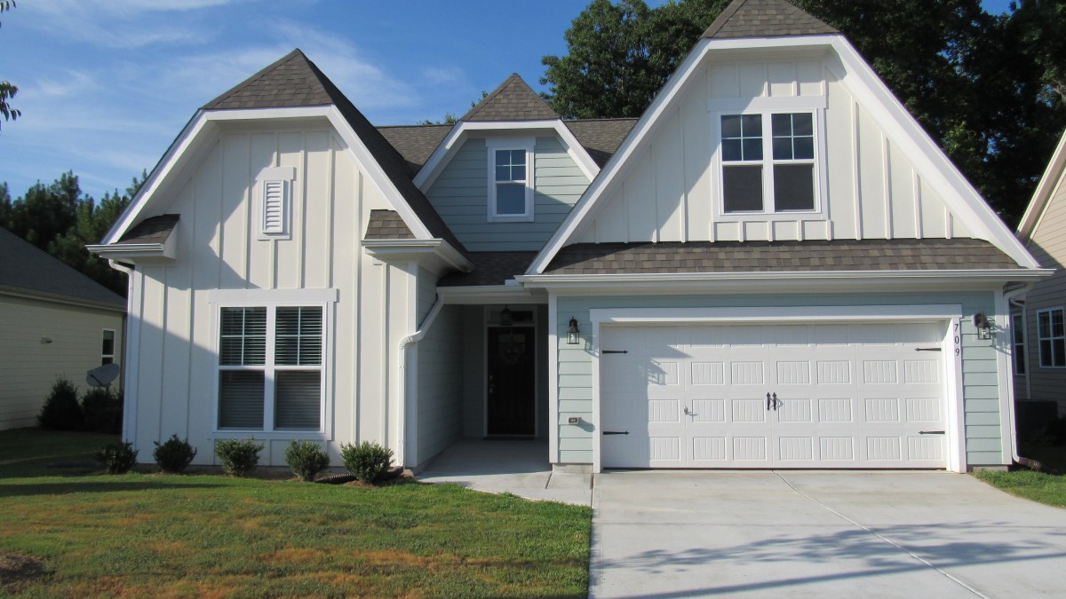 A modern residential house with a garage and front yard.