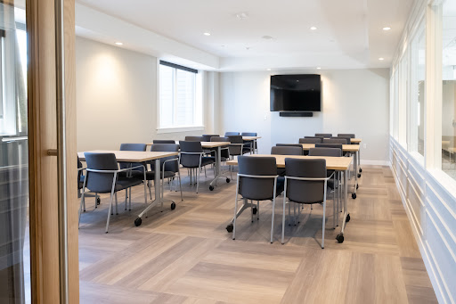 A modern meeting room equipped with tables and chairs, suitable for conferences or workshops.