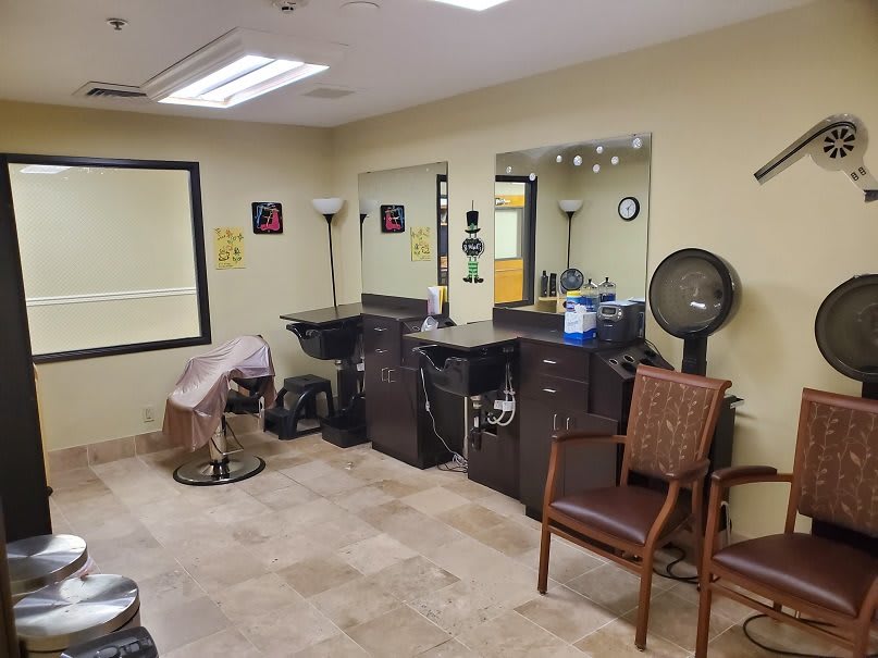 A cozy barbershop interior with chairs, mirrors, and hair styling equipment.
