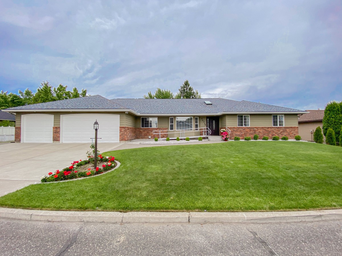 Single-story suburban house with a well-maintained lawn and driveway.