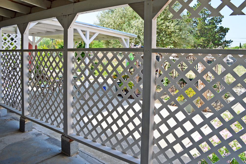 A lattice fence providing a decorative boundary for the patio area.