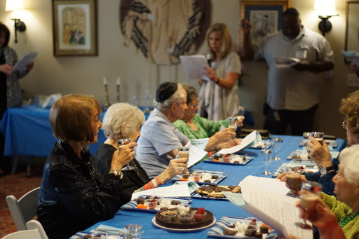 A joyful gathering around the dining table, sharing food and drinks.