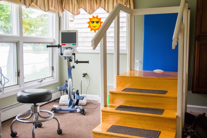 A rehabilitation area featuring an exercise bike and stairs for therapy exercises.