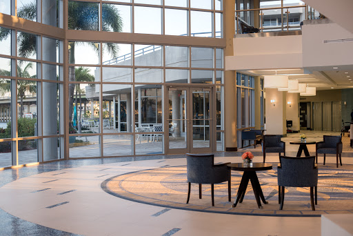A spacious and modern lobby featuring elegant furniture and large glass windows allowing natural light to fill the space.